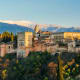 Alhambra palace fortress in Granada Spain with snow-capped Sierra Nevada mountains in background